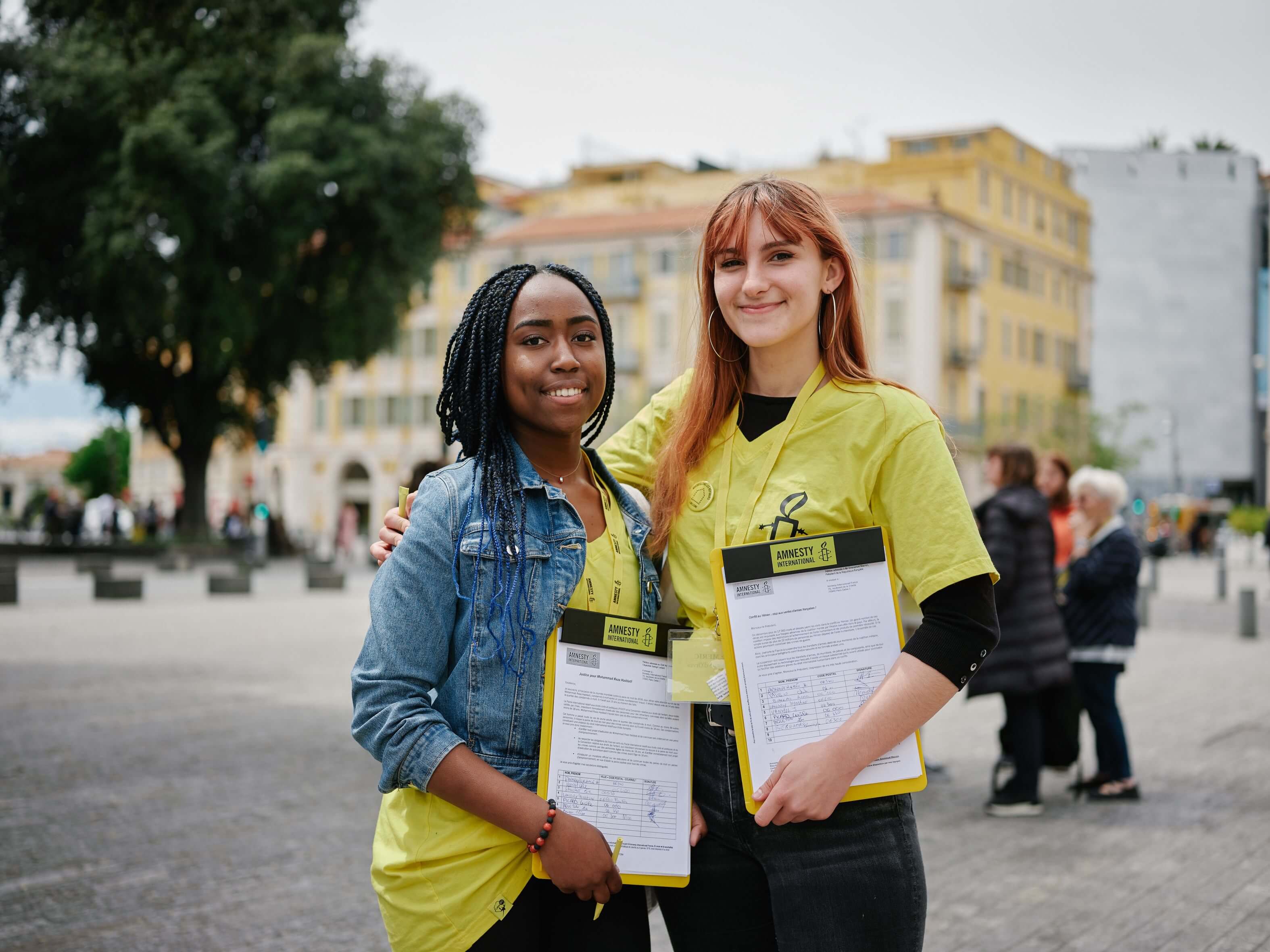 Une femme vêtue d’un t-shirt d’Amnesty avec un mégaphone.