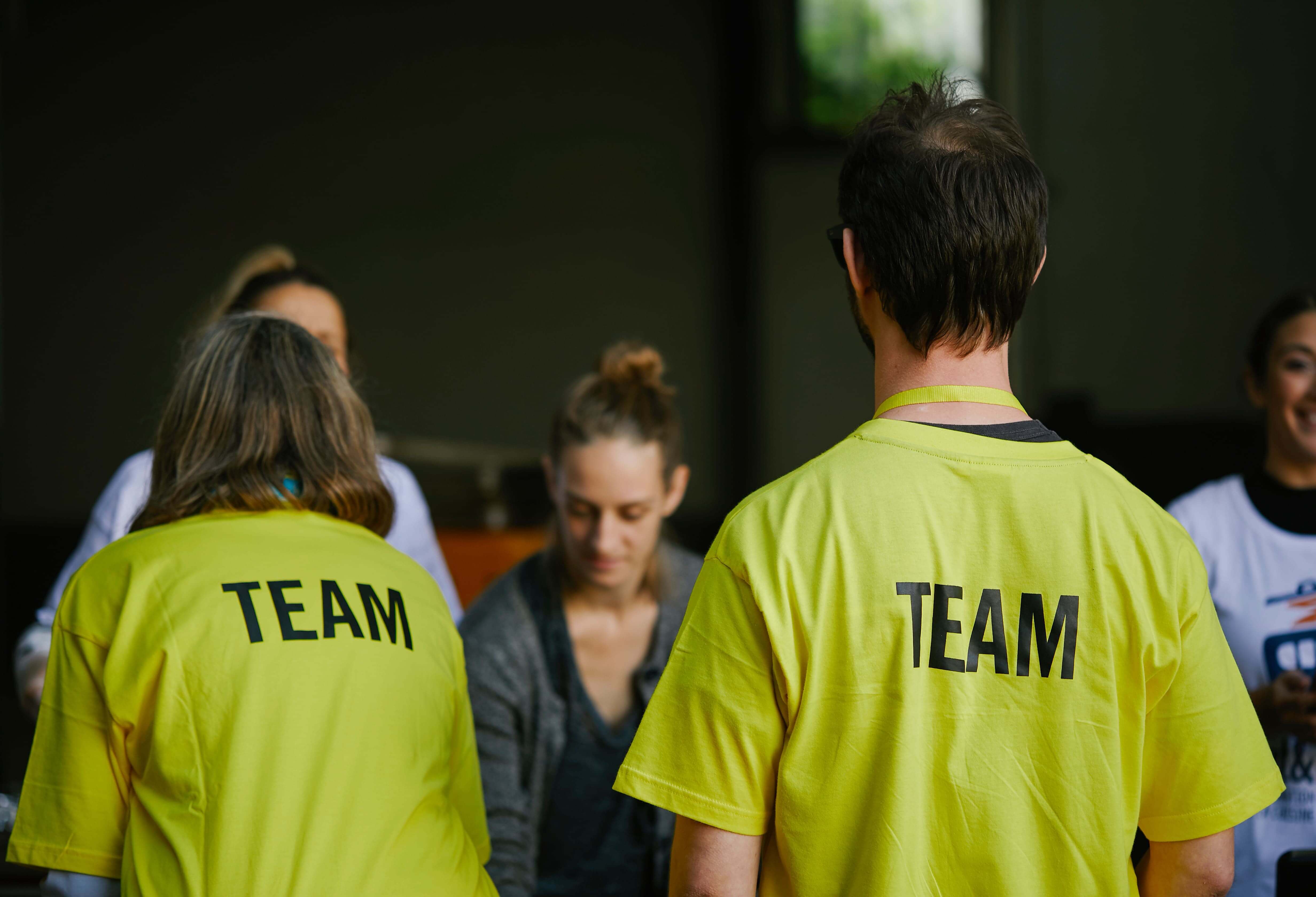 Vue de dos de deux personnes portant un t-shirt Amnesty avec l’inscription « Team ».