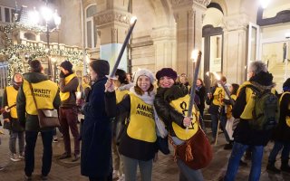 Des participantes à la manifestation organisée lors de la Journée internationale des droits de l’Homme au Luxembourg avec leurs flambeaux allumés.