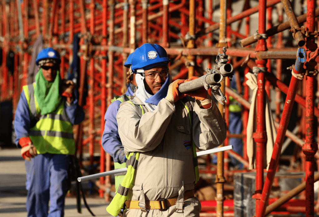 Des ouvriers du bâtiment sur le stade international de Khalifa à l'approche de la Coupe du monde de la FIFA 2022 au Qatar, le 30 décembre 2015 à Doha, Qatar