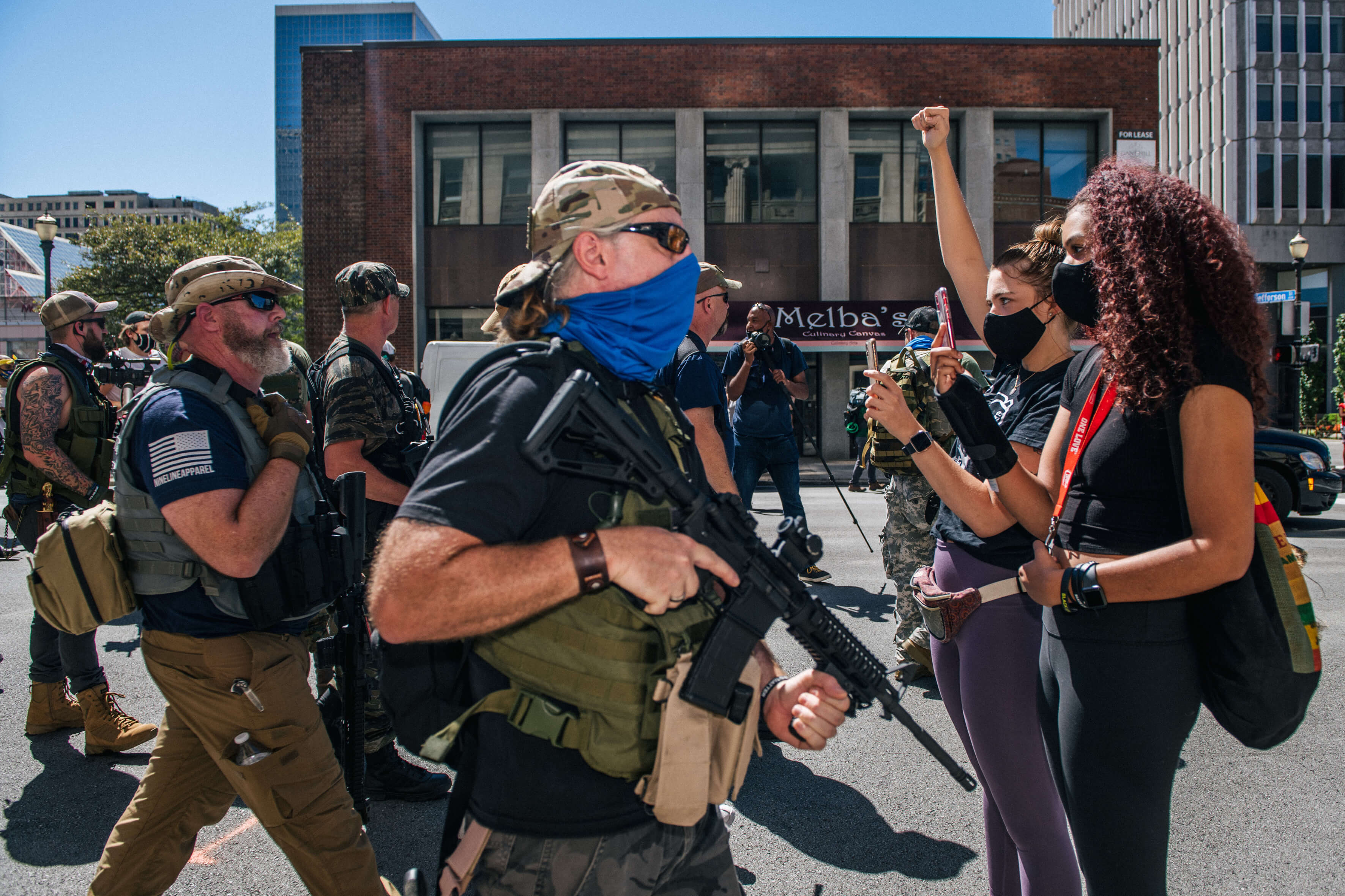 LOUISVILLE, KY - 05 SEPTEMBRE : Des femmes se tiennent dans la rue pour enregistrer la marche des militants de droite vers le Louisville Metro Hall le 5 septembre 2020 à Louisville, Kentucky. Avant le Kentucky Derby, les manifestants se sont affrontés à propos des récents pillages et destructions dans la région et de la mort de Breonna Taylor, qui a été tuée par des agents de police du métro de Louisville lors d'une descente sans merci dans son appartement le 13 mars 2020.