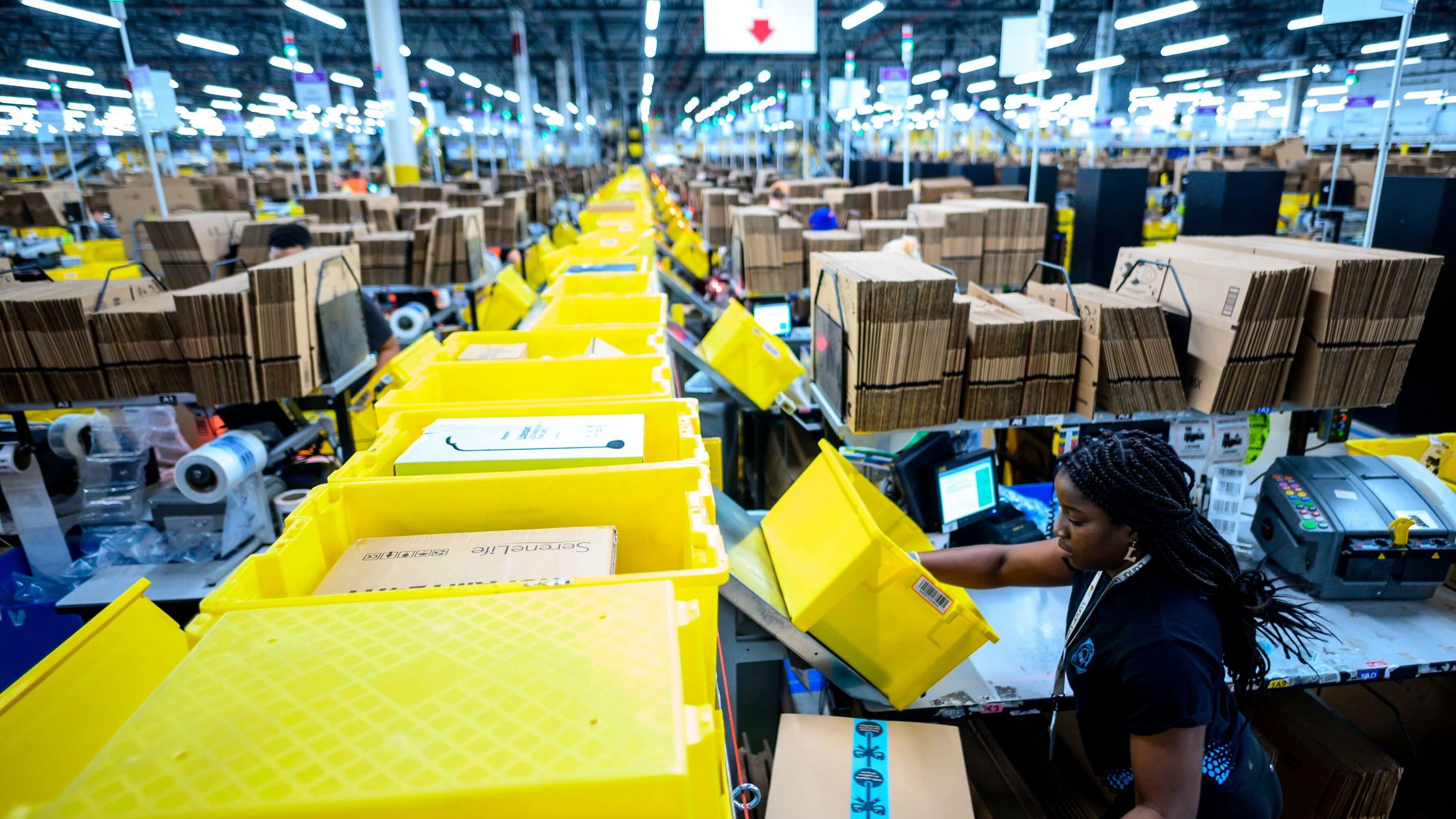 Le 5 février 2019, une femme travaille dans une station d'emballage du centre de remplissage Amazon de 855 000 pieds carrés à Staten Island, l'un des cinq arrondissements de la ville de New York. - Dans un immense entrepôt de Staten Island, des milliers de robots sont occupés à distribuer les milliers d'articles vendus par le géant de la vente en ligne, Amazon.